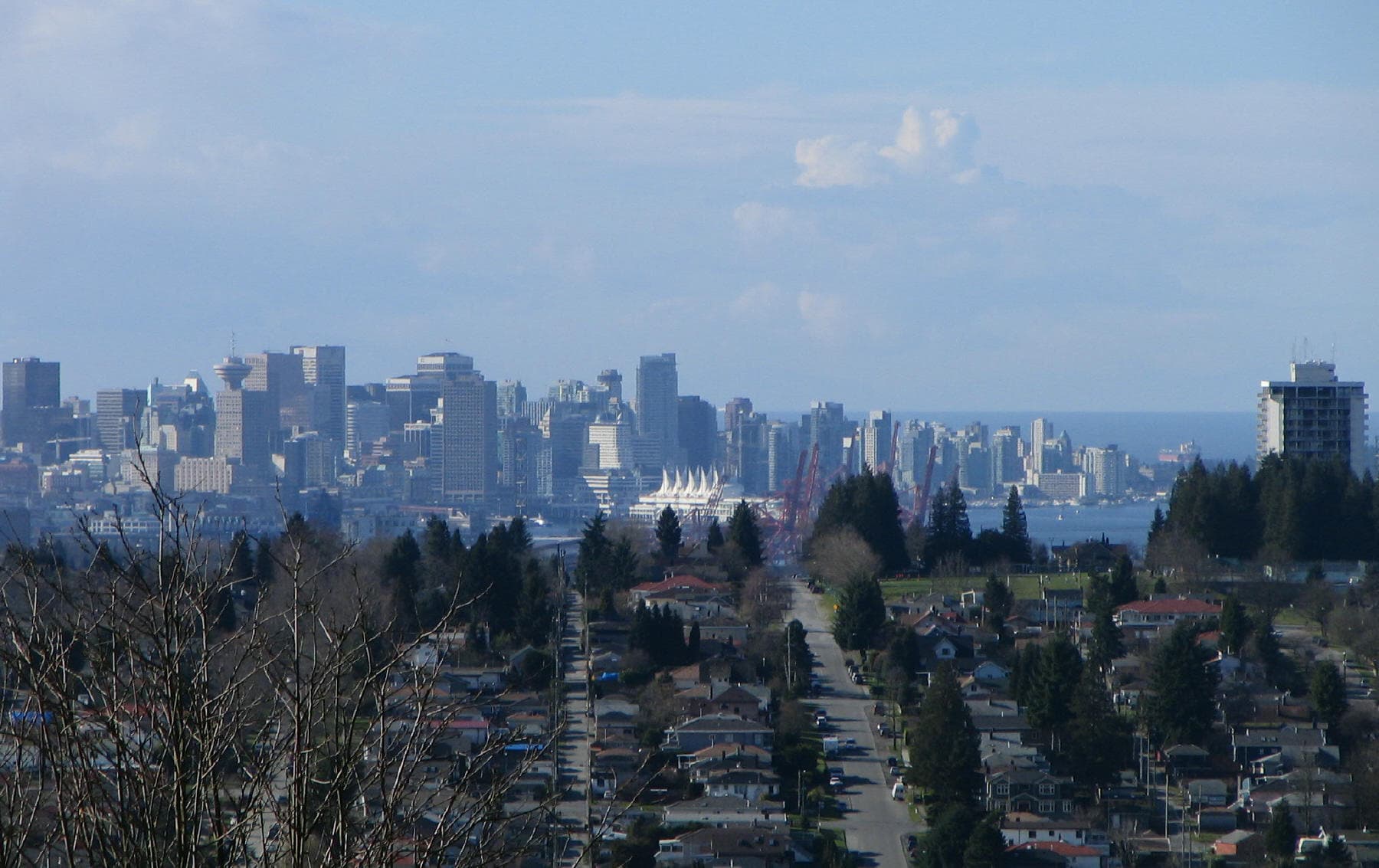 Looking down on the Burnaby Heights neighbourhood of North Burnaby from Capitol Hill, with Burrard Inlet and the North Shore mountains visible in the background.