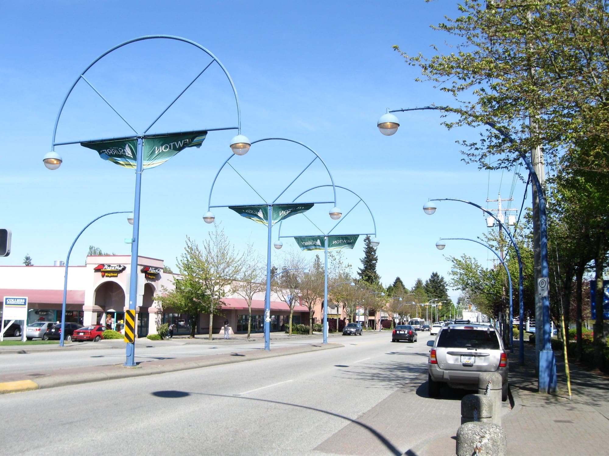 Newton Town Centre along 72 Avenue in Surrey with street-level shops, restaurants, and South Asian businesses.