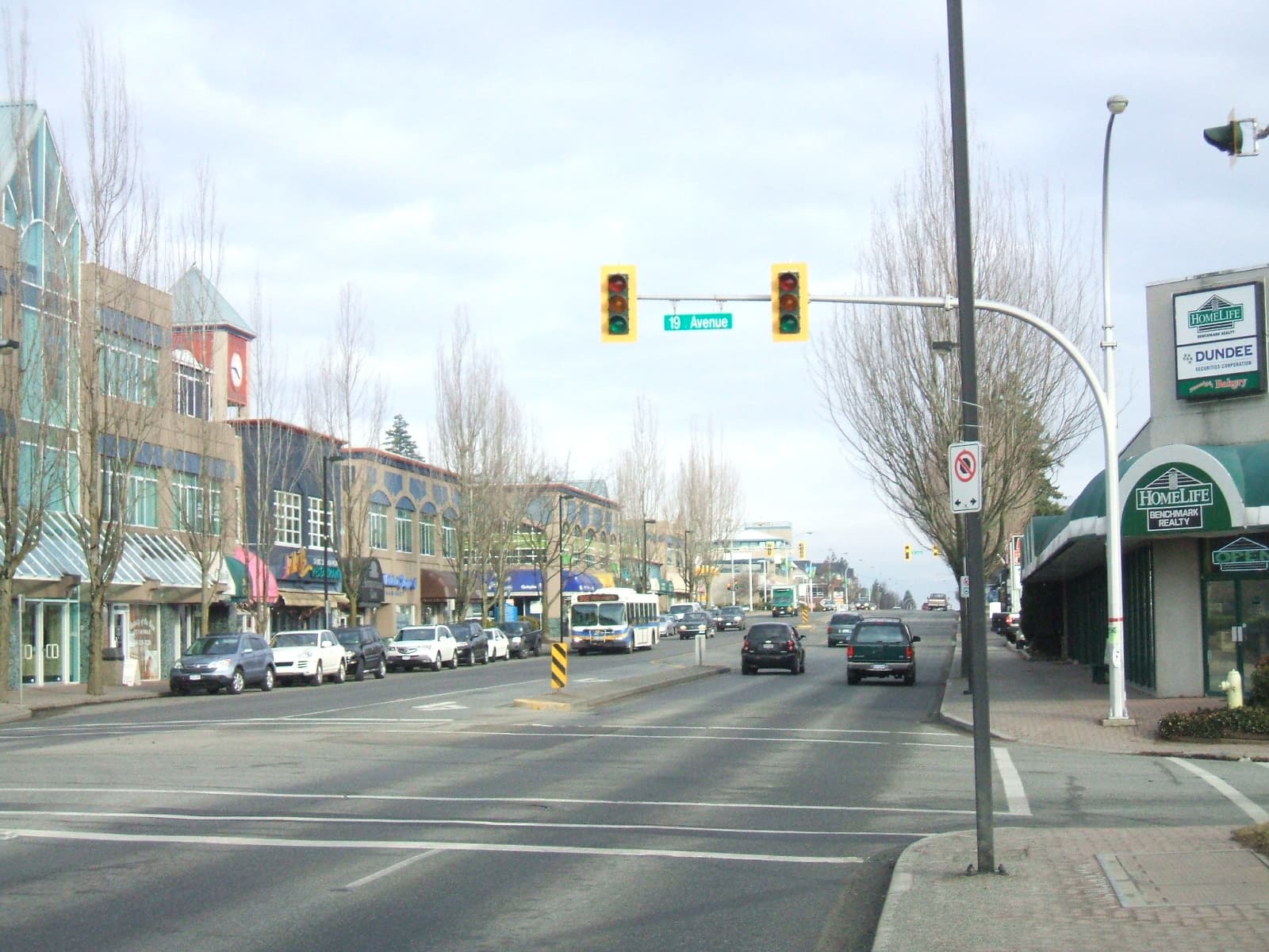 Downtown South Surrey along 152 Street with low-rise commercial buildings and palm-lined streetscape.